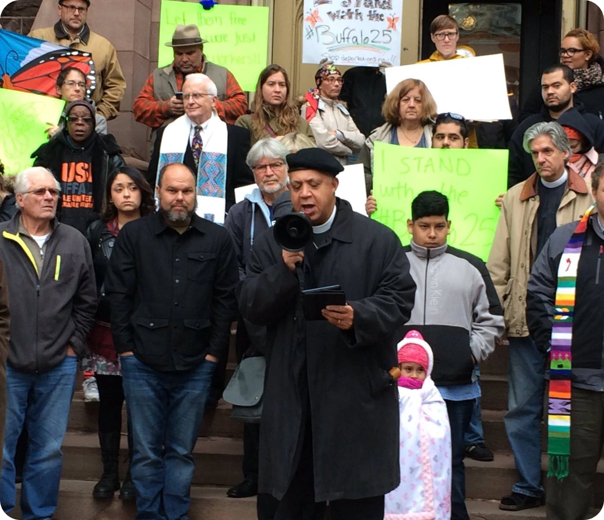 Protestors holding signs on city steps