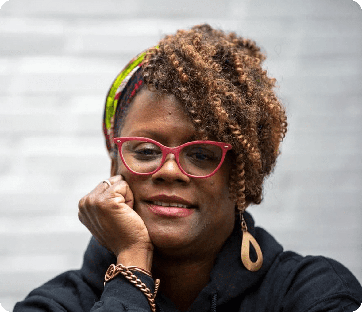 Woman with curly hair and red glasses